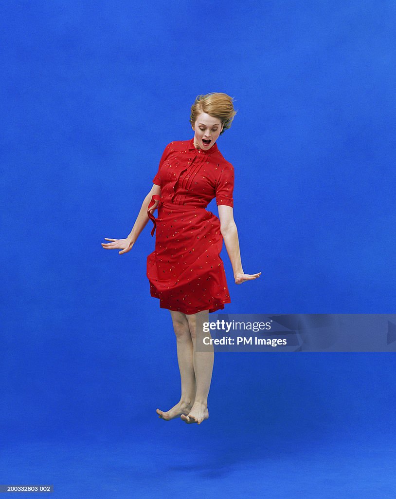 Young woman levitating with  surprise look on face