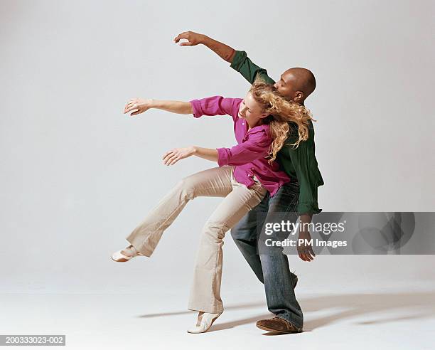 young man and woman falling backwards, side view - modern dancing stock pictures, royalty-free photos & images