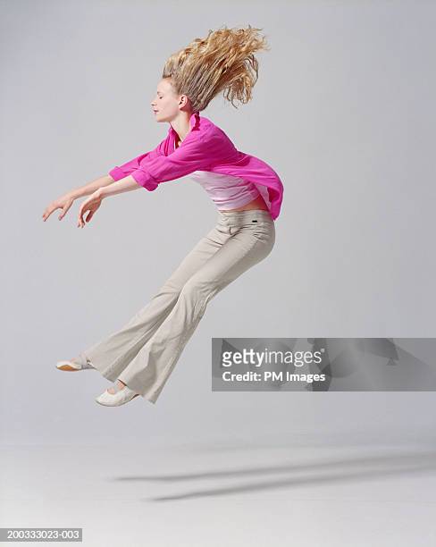 young woman flying backwards, arms extended, side view - finger waves imagens e fotografias de stock