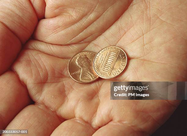 hand holding two u.s. pennies - us penny stock pictures, royalty-free photos & images