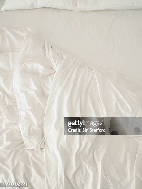 unmade bed with white sheets - bettbezug stock-fotos und bilder