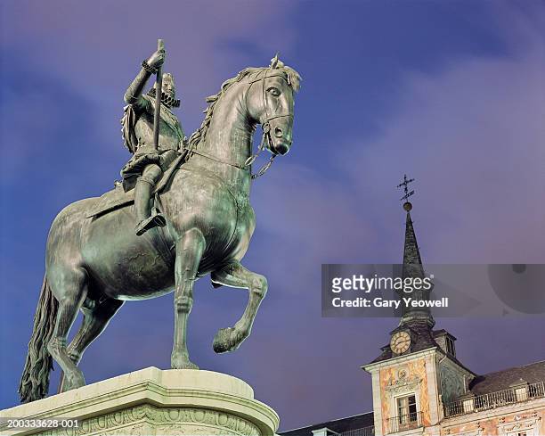 spain, madrid, plaza mayor, statue of philip iii, dusk, low angle - casa de la panaderia stock pictures, royalty-free photos & images