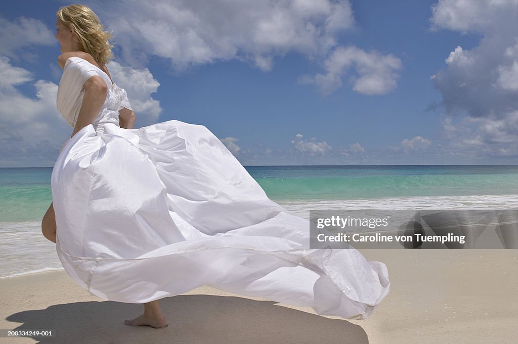 Bride running on beach