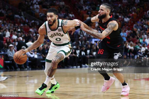 Jayson Tatum of the Boston Celtics drives against Caleb Martin of the Miami Heat during the first quarter of the game at Kaseya Center on February...