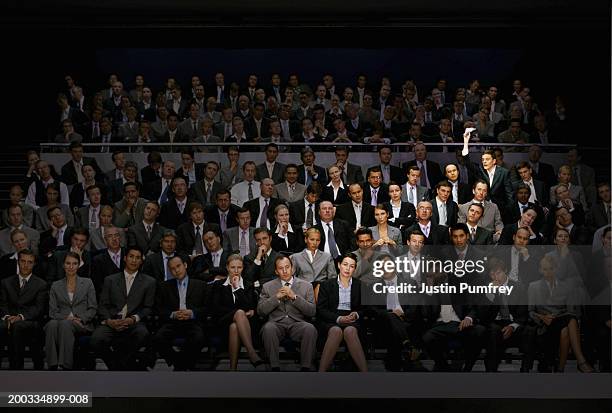 man throwing paper dart in auditorium (digital composite) - people watching at camera stock-fotos und bilder