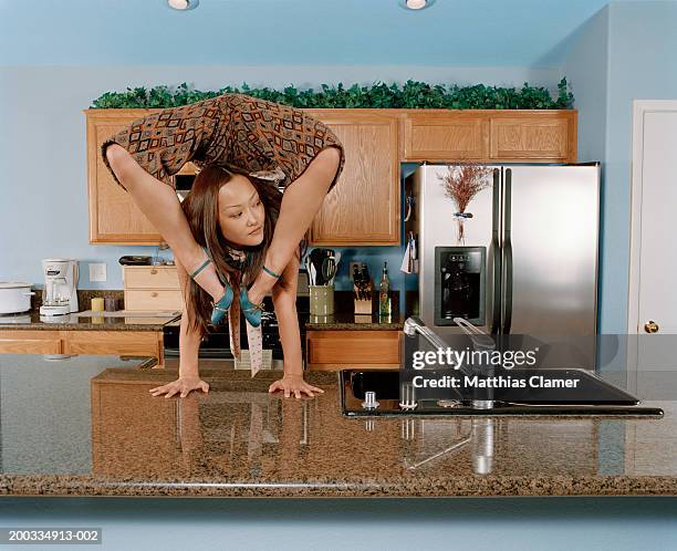 young female gymnast doing handstand at kitchen sink - double jointed stock pictures, royalty-free photos & images