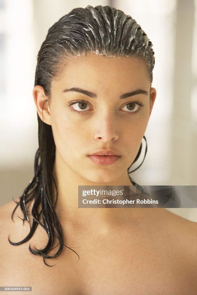 Young woman with conditioner in hair, close-up