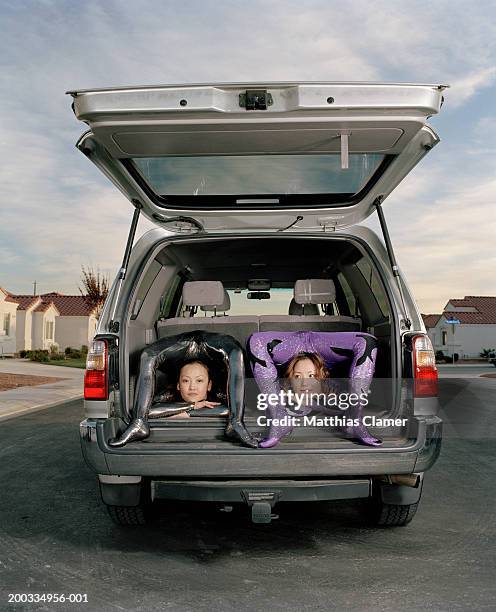 young female contortionists bending over backwards in vehicle - contortionist stock pictures, royalty-free photos & images