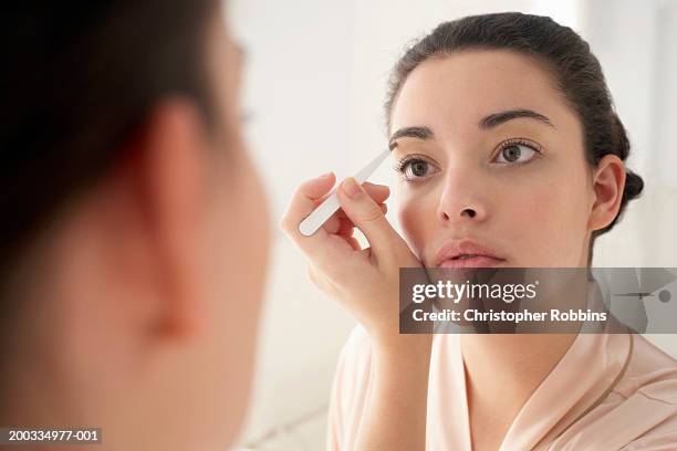 junge frau plucking zupfen, nahaufnahme, reflexion im spiegel - eyebrow stock-fotos und bilder