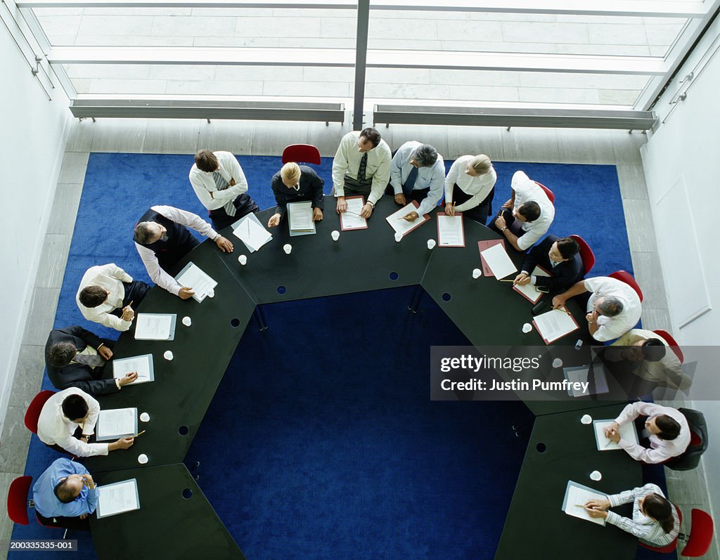 Businessmen and women in meeting at large round table, elevated view