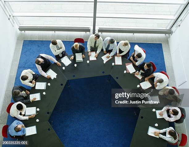 businessmen and women in meeting at large round table, elevated view - round table discussion women stock pictures, royalty-free photos & images