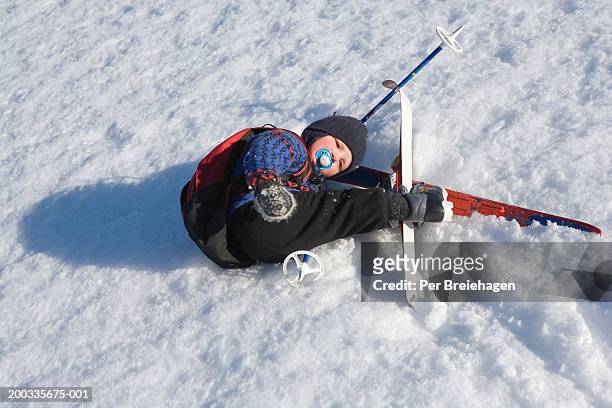 boy (2-4) tangled up in cross country skis, elevated view - skiing accident stock pictures, royalty-free photos & images