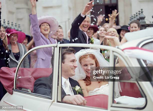 bride and groom in convertible car, wedding party waving in background - church wedding decorations 個照片及圖片檔