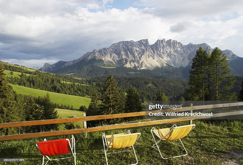 Italy, Alto Adige, Dolomites, deck chairs facing Latemar Mt. Range