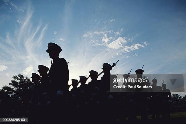 silhouetted naval cadets marching in formation, low angle view - amerikanska militären bildbanksfoton och bilder