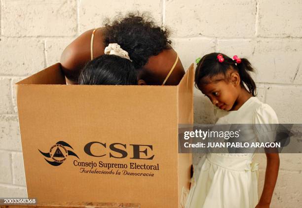 Una mujer, acompañada por su hija, vota un colegio de Bilwi, Puerto Cabezas, 350 km al noroeste de Managua, el 05 de marzo de 2006. Habitantes de la...