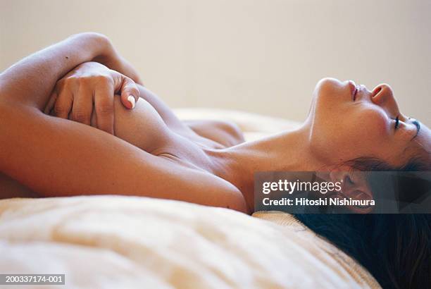 naked woman lying on bed, hands covering breast - animal body 個照片及圖片檔