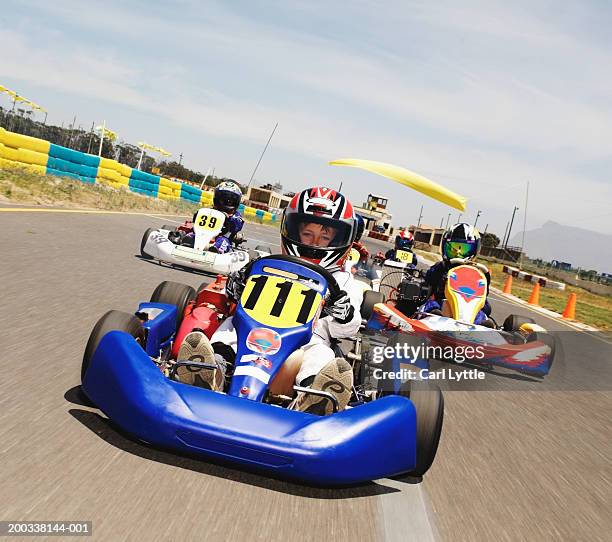 boy (9-11) driving go-cart on race track, portrait - go cart stock-fotos und bilder