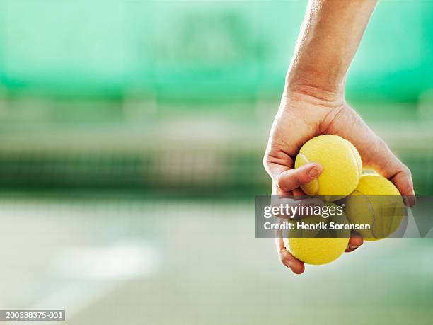 young man holding three tennis balls in hand, close-up - tennis ball hand stock pictures, royalty-free photos & images