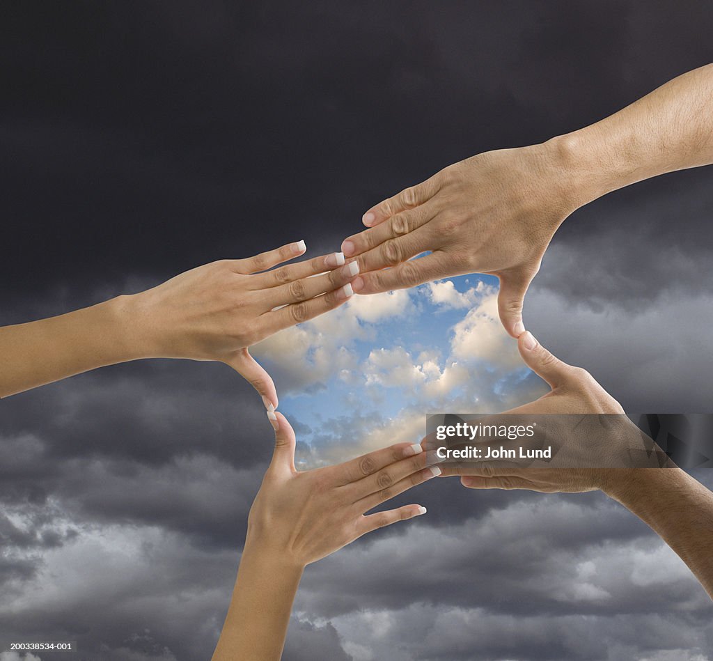 Man and woman making box form with hands, clear sky in box