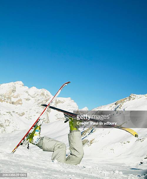 woman wearing skis buried in snow, legs in air - funny snow skiing stock pictures, royalty-free photos & images