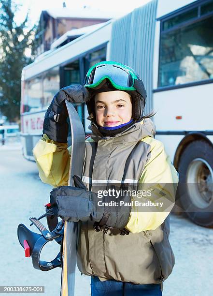 girl (9-11) standing with snowboard, smiling, portrait - val d'isere stock pictures, royalty-free photos & images