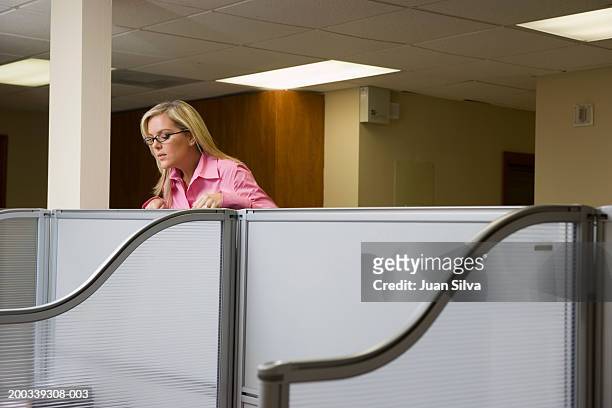 businesswoman looking over partition into office cubicle - peeking cubicle stock pictures, royalty-free photos & images