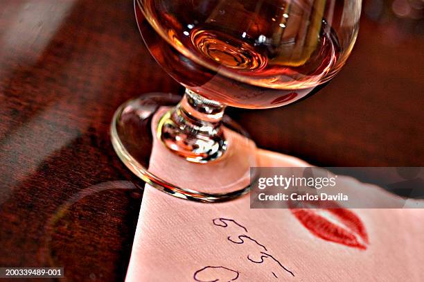 cognac glass on napkin with telephone number and kiss imprint - phone number stock pictures, royalty-free photos & images