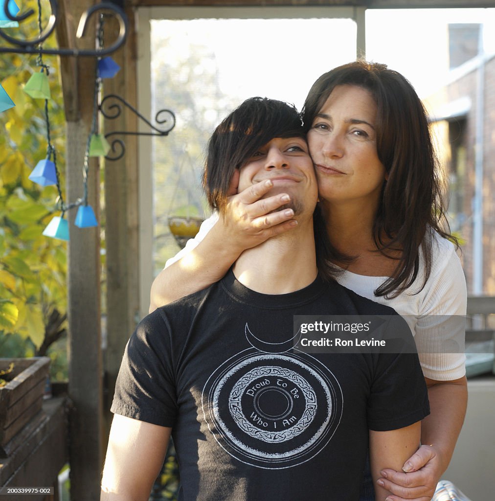 Mother hugging teenage son (15-17), portrait