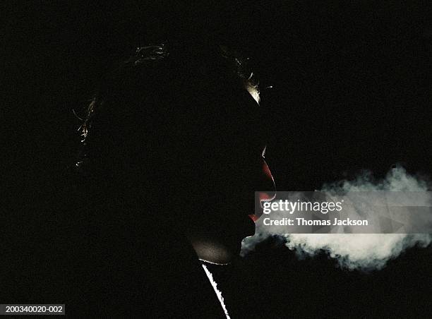 man exhaling vapor, side view, close-up, night - exhale stock pictures, royalty-free photos & images