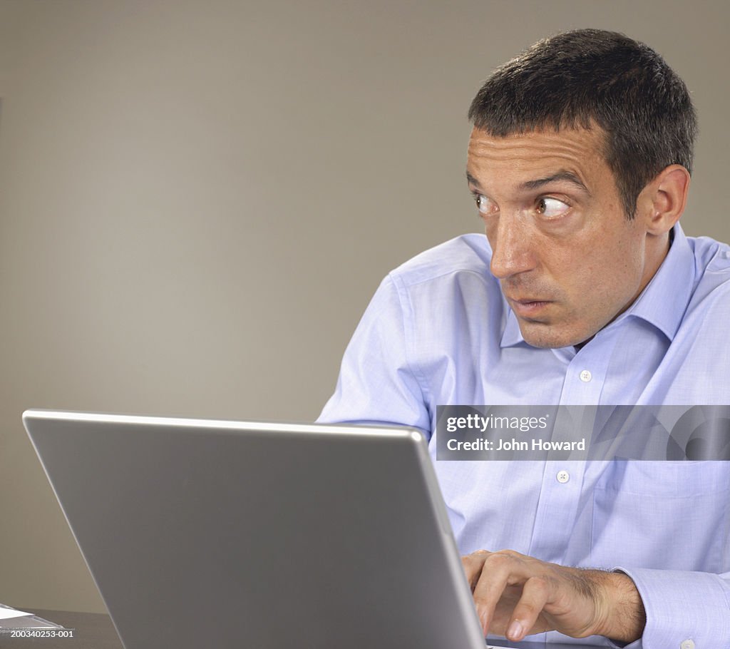 Man Using Laptop Hunching Shoulders Looking To Side High-Res Stock ...