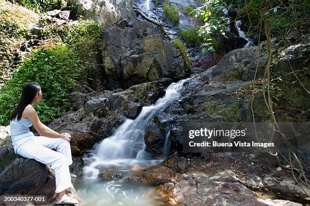 thailand, koh samui island, young woman sitting by waterfall - province de surat thani photos et images de collection