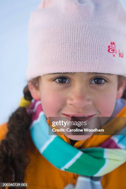 girl (5-7) wearing knit hat and scarf, smiling, portrait - ski jacket - fotografias e filmes do acervo