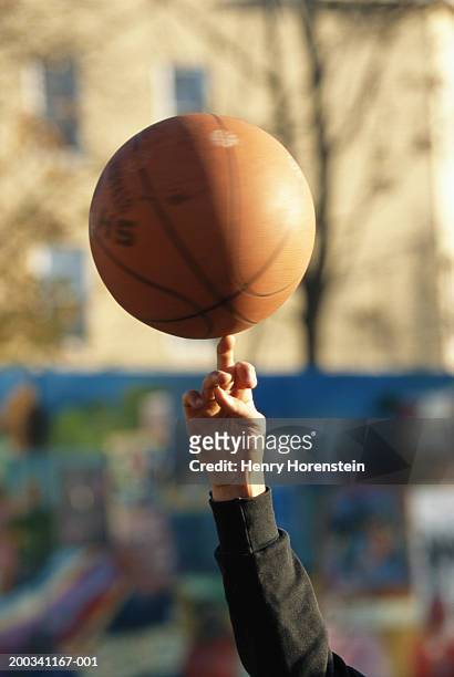 person spinning basketball on finger, close-up of hand and ball - basketball close up stock-fotos und bilder