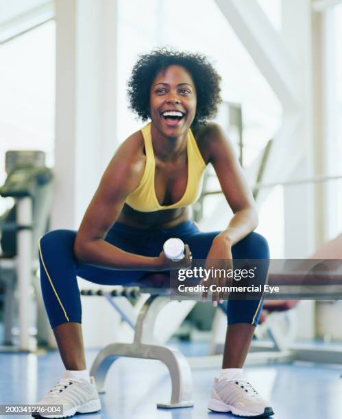 woman lifting dumbbell in gym, smiling, close-up - levantamento de peso fotografías e imágenes de stock