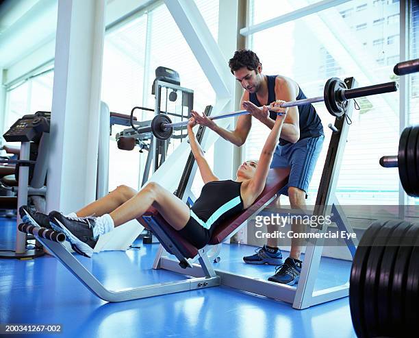 couple weight training in gym, man spotting behind weight bench - spotting bildbanksfoton och bilder