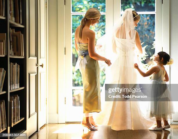 bridesmaid and flower girl (3-5) adjusting bride's veil, rear view - flower girl stock pictures, royalty-free photos & images