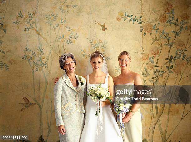 mother, bride and bridesmaid standing side by side, smiling, portrait - familys revenge of the bridesmaids stockfoto's en -beelden