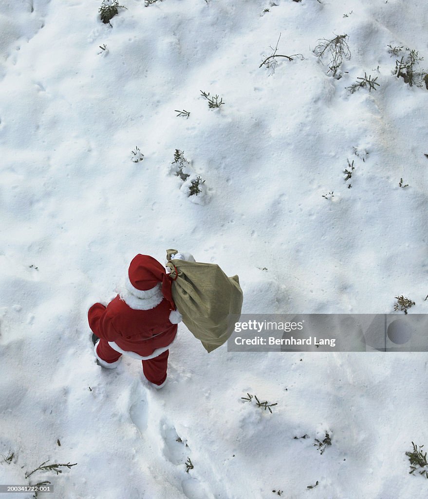 Man in Father Christmas costume, sack over shoulder, elevated view