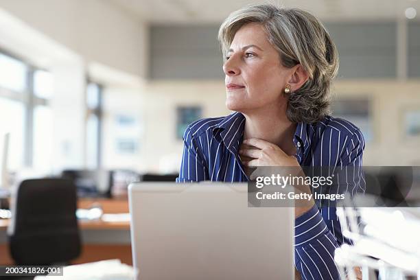 mature businesswoman by laptop in office - woman business desk front laptop office bildbanksfoton och bilder