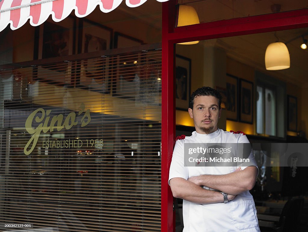 Male barber standing in doorway of shop, portrait