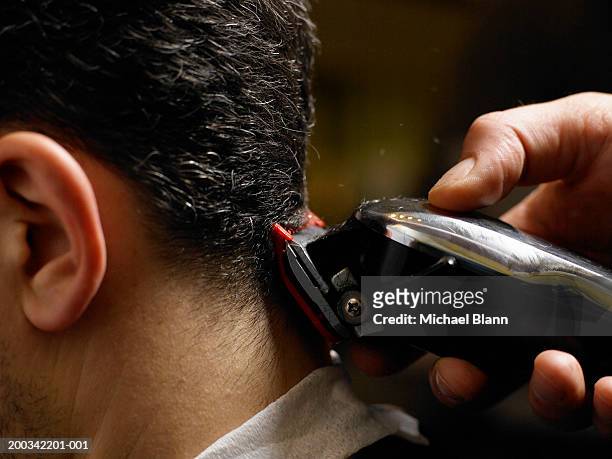 barber cutting man's hair, close-up of electric razor, side view - kappertje stockfoto's en -beelden