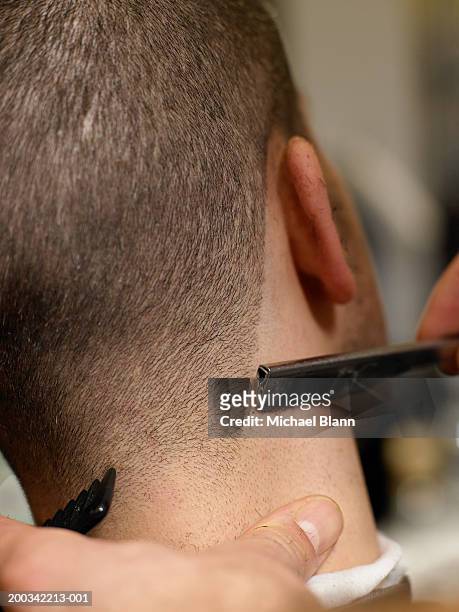 barber giving man haircut, close-up, rear view - straight razor stock pictures, royalty-free photos & images