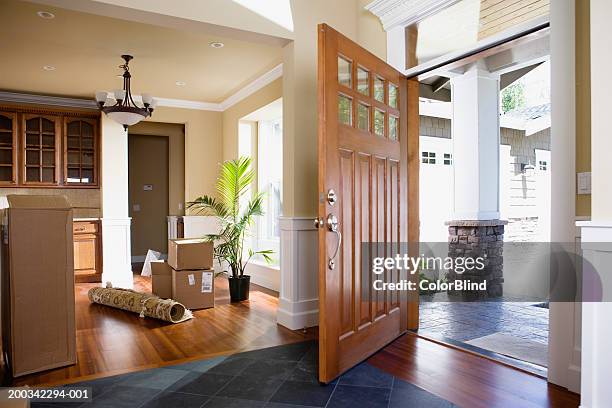 open front door, rolled up rug and cartons on floor - open house stockfoto's en -beelden
