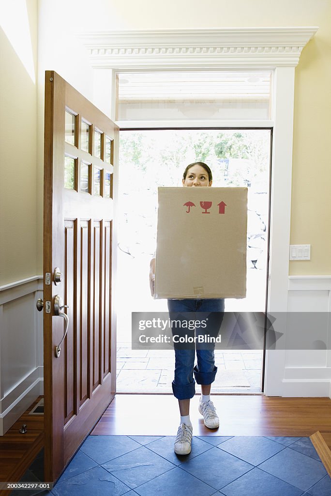 Woman carrying carton into new home