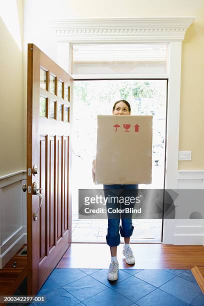 woman carrying carton into new home - house entrance interior stock pictures, royalty-free photos & images