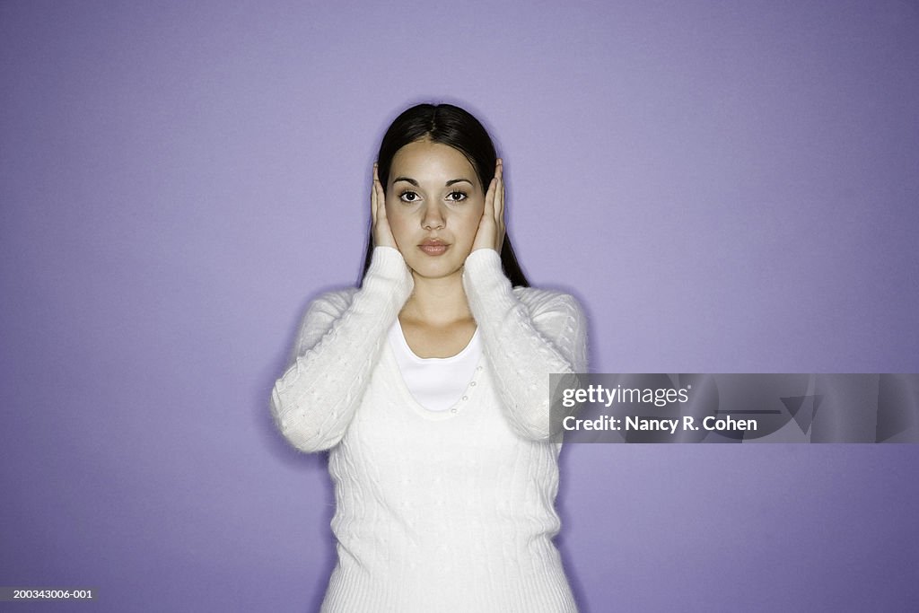 Young woman, hands covering ears, portrait