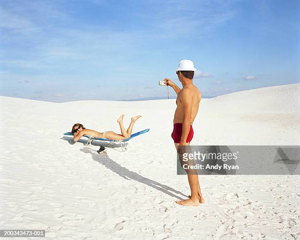 man taking picture of woman lying on sun lounger - women in bathing suits stock pictures, royalty-free photos & images