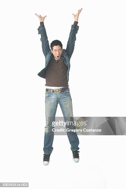 young man jumping in mid air, mouth open - man open mouth stock pictures, royalty-free photos & images