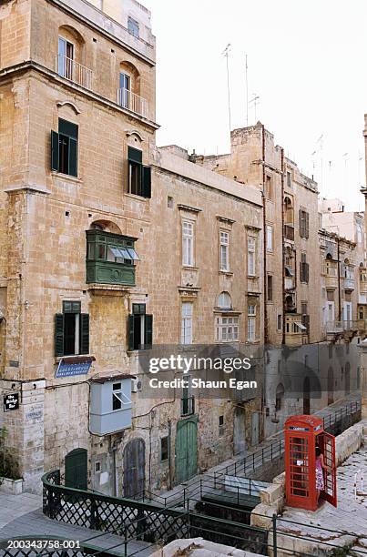 malta, valletta, woman standing in red phone box, rear view - malta bridge stock pictures, royalty-free photos & images